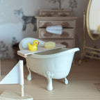 Mand met badplankje met handdoek, badeendje en sponsjes