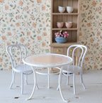 Wit metalen stoeltje voor het poppenhuis