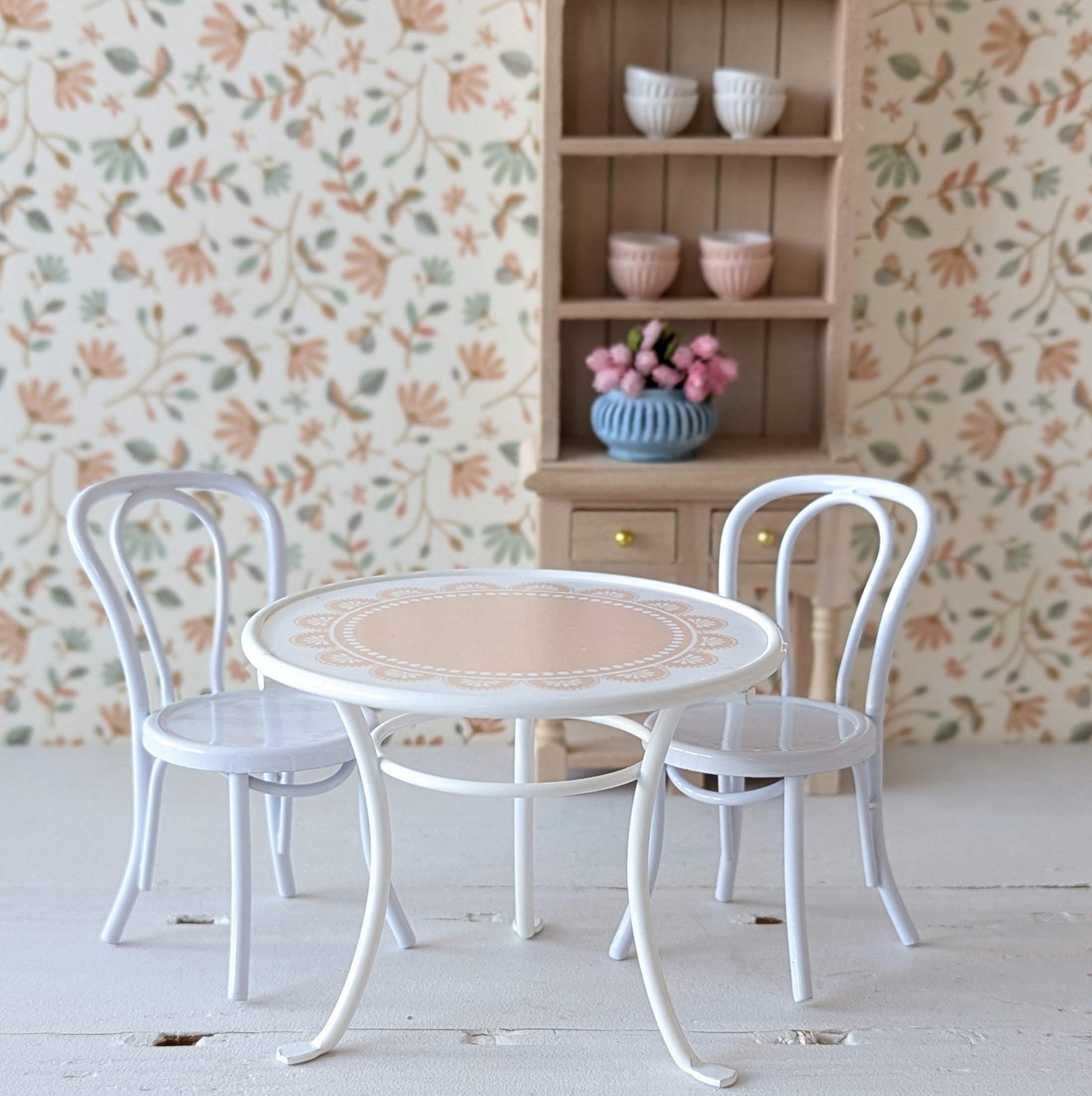 Wit metalen stoeltje voor het poppenhuis