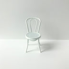 Wit metalen stoeltje voor het poppenhuis