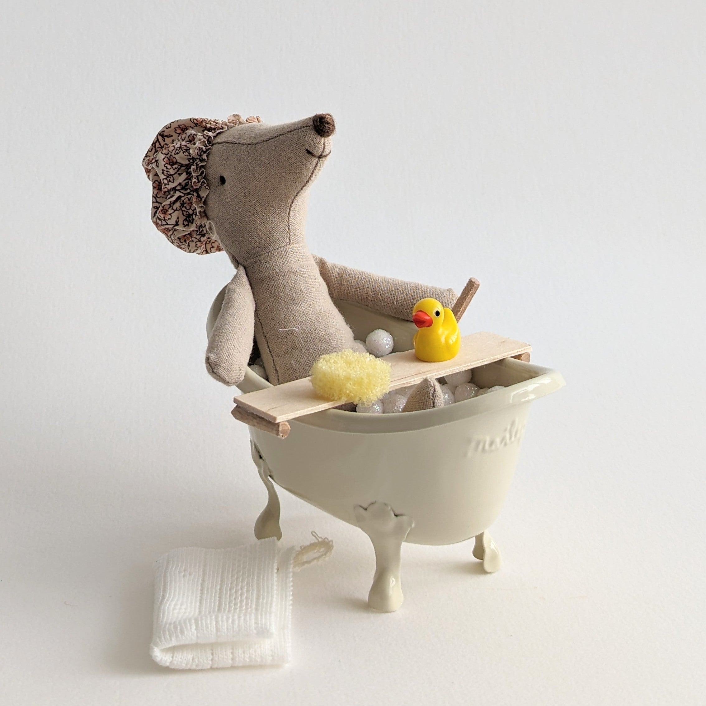 Mand met badplankje met handdoek, badeendje en sponsjes