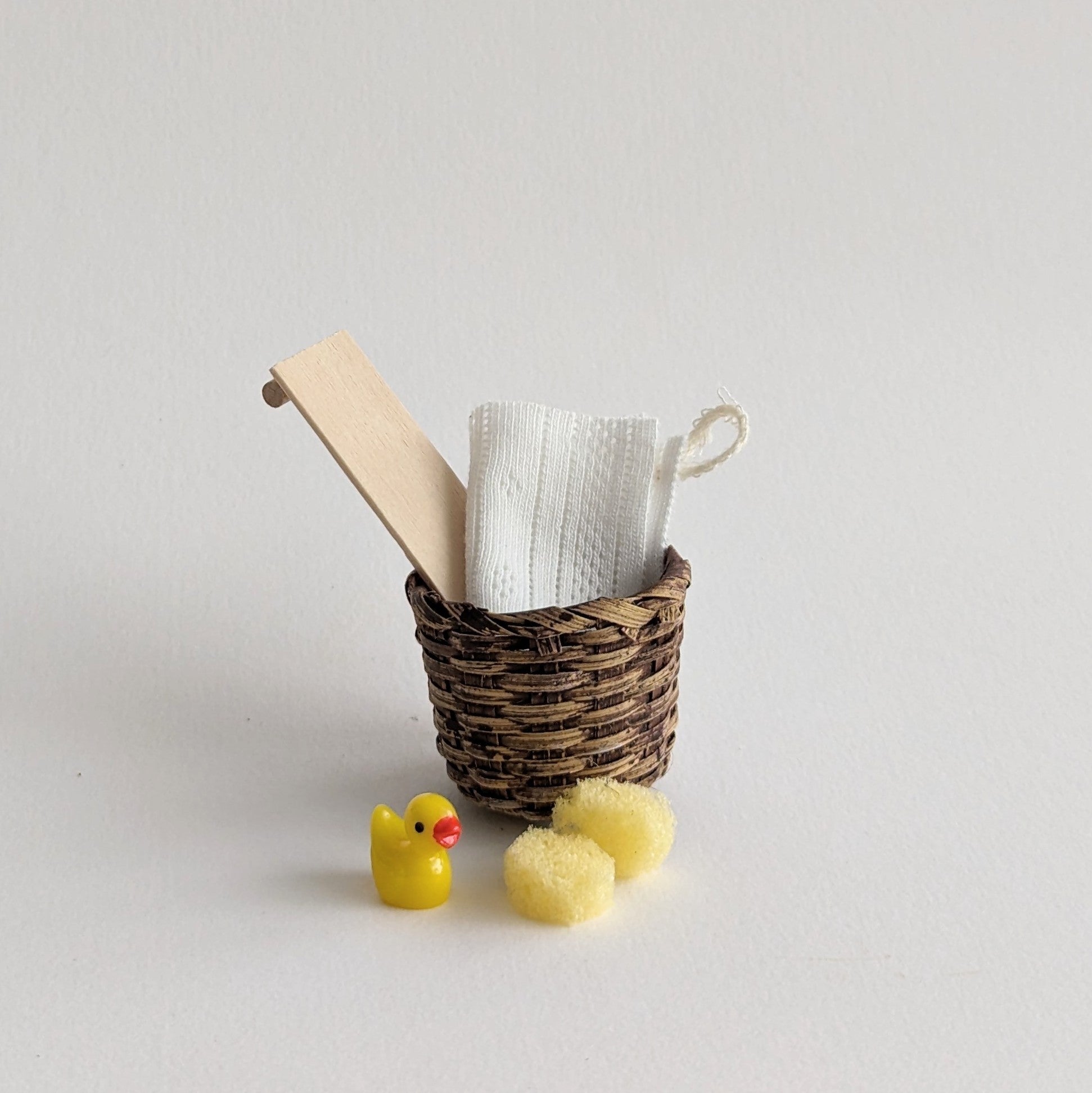 Mand met badplankje met handdoek, badeendje en sponsjes